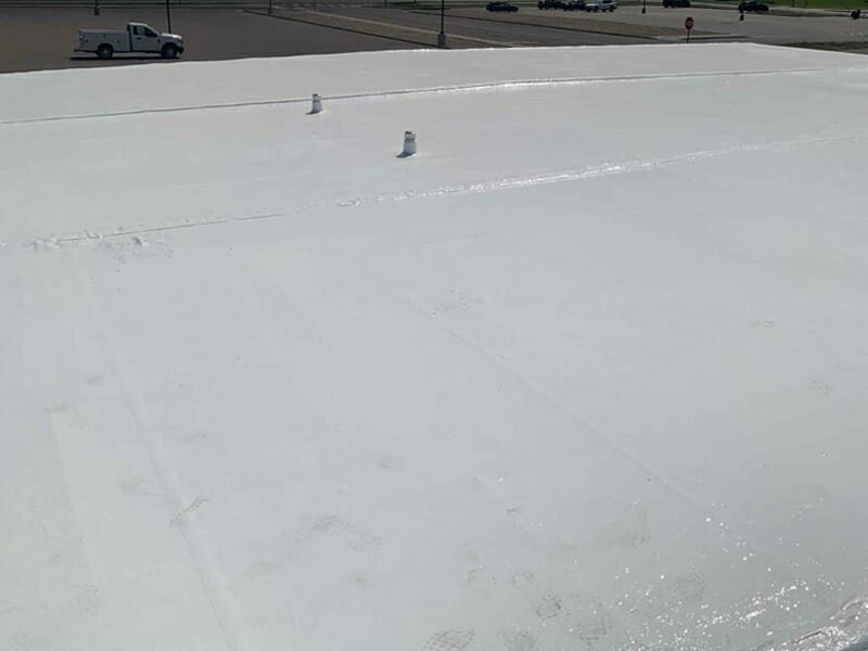 Completed white flat roof replacement on a commercial building