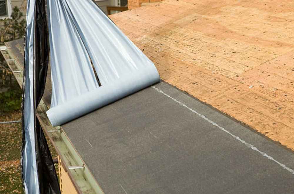roof underlayment being installed on top of a roof sheating