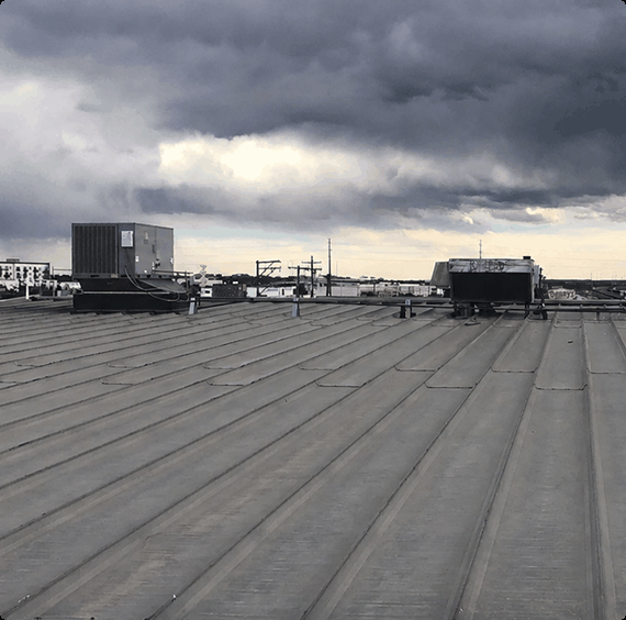 clouds-rooftop-hvac-units.pngStanding seam metal roof with rooftop HVAC units under dark storm clouds