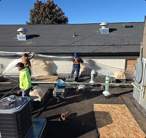 underlayment-residential-roof-edge.webpRoofing crew installing waterproof underlayment along a residential roof edge